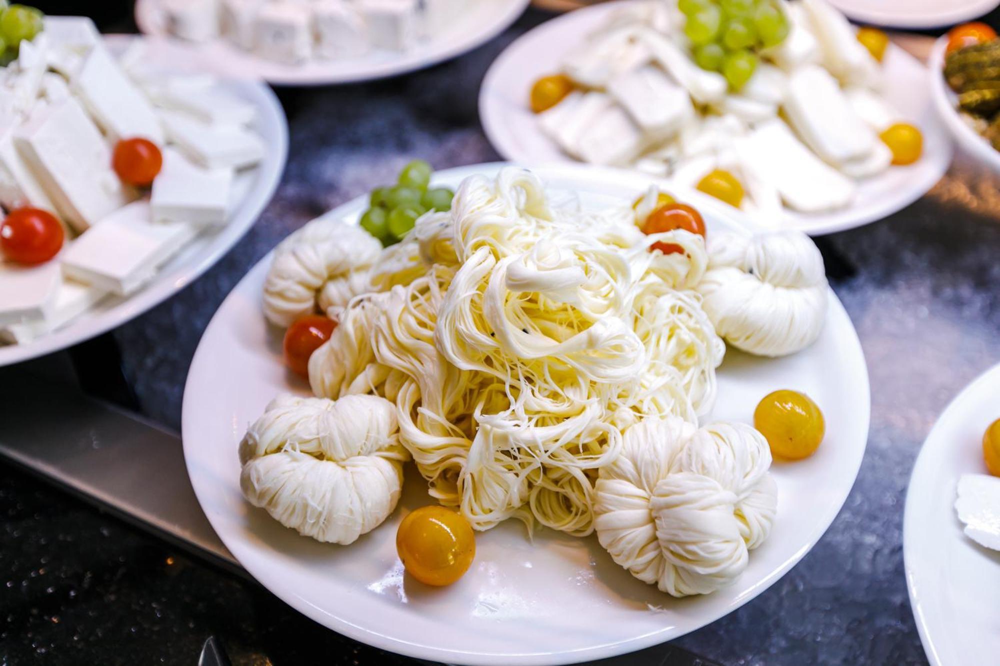 Stella Di Mare Dubai Marina Hotel Esterno foto The photo shows a plate of food featuring strands of white noodles arranged in a mound at the center. Surrounding the noodles are small, round, yellow cherry tomatoes and several portions of soft, white cheese, which appear to be shaped like small po